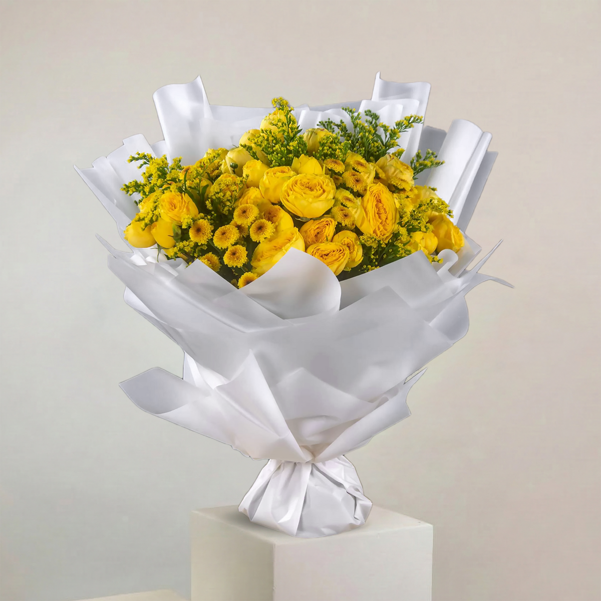 Bouquet of yellow flowers wrapped in white paper on a beige background