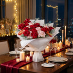 Decorative table setting with flowers, candles, and cutlery against a cityscape background.