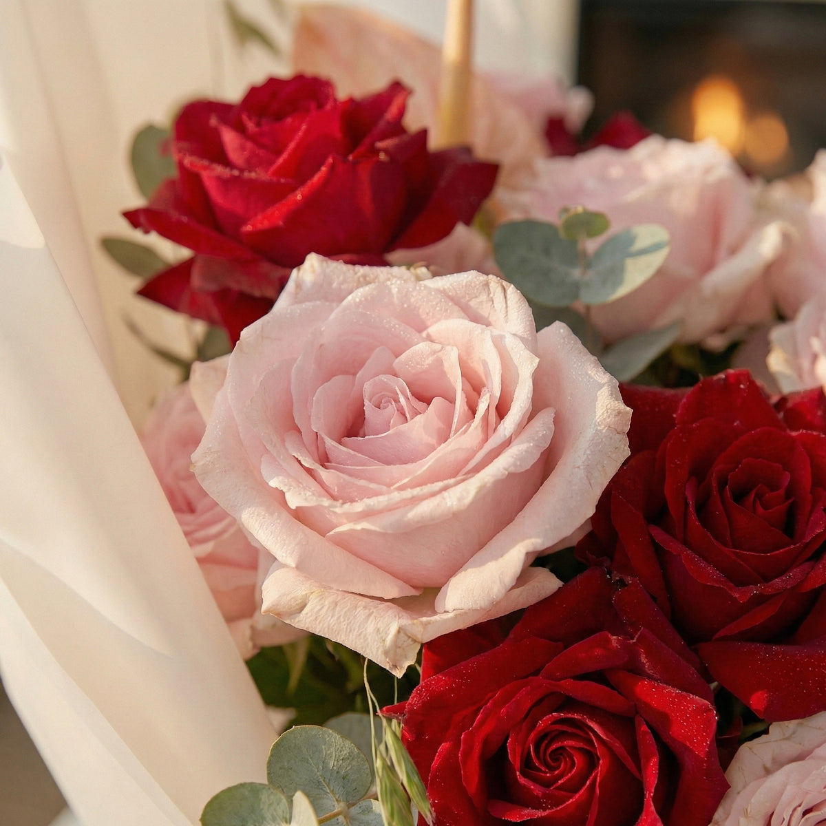 Bouquet of red and pink roses with green leaves.