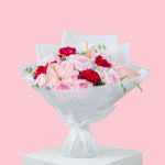 Blush Desire bouquet with pink and red roses, anthurium accents, and white wrapping, luxury flower bouquet for delivery