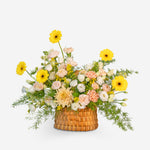 Floral arrangement in a woven basket on a white background