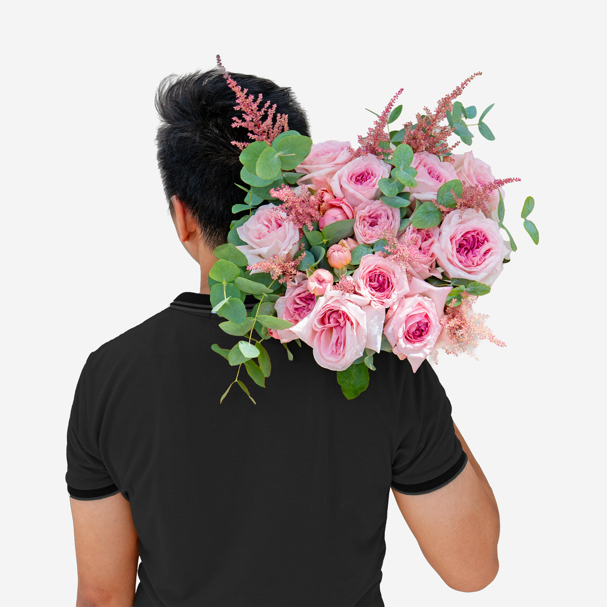 Person holding a large bouquet of pink flowers with greenery on a white background