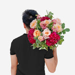 Person holding a large bouquet of flowers against a white background