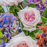 Close-up of a bouquet with pink roses and purple hydrangeas.