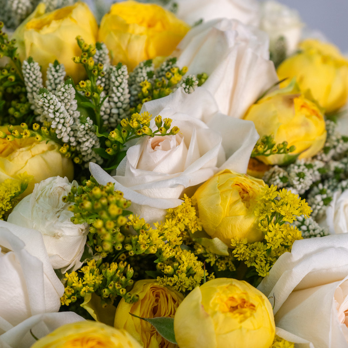 Bouquet of yellow and white flowers with greenery