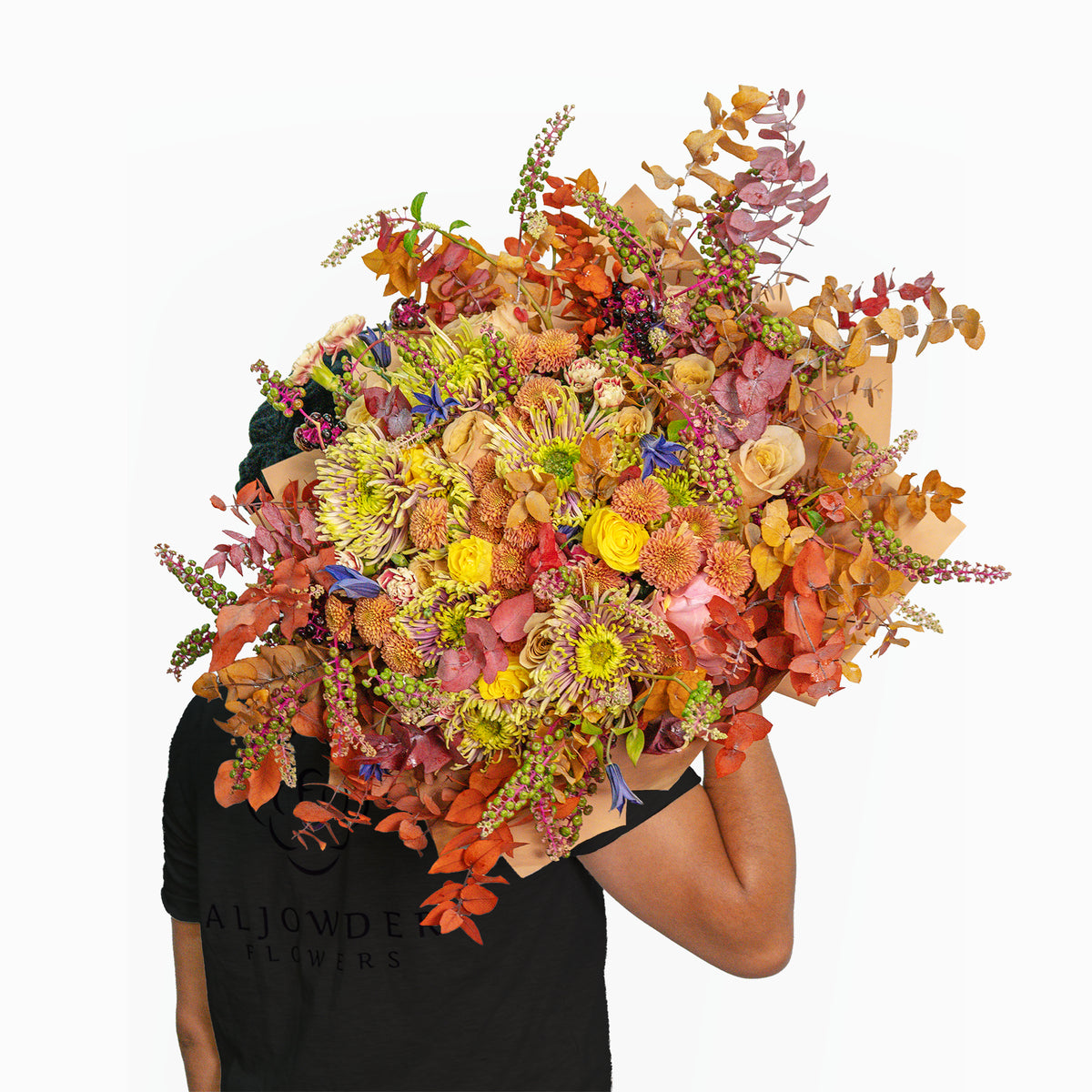 Person holding a large, colorful bouquet of flowers against a white background
