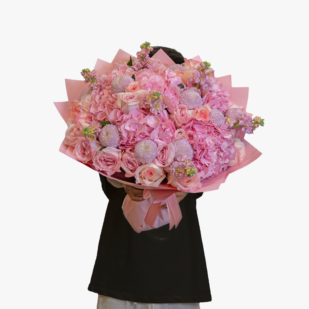 Person holding a large bouquet of pink flowers against a white background