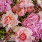 Bouquet of pink and white flowers including roses and hydrangeas.