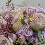 Bouquet of lavender and white roses with greenery on a light background