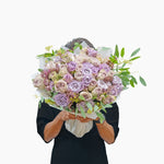 Person holding a bouquet of flowers on a white background