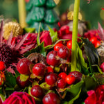 Close-up of a bouquet with red berries and green leaves against a blurred natural background