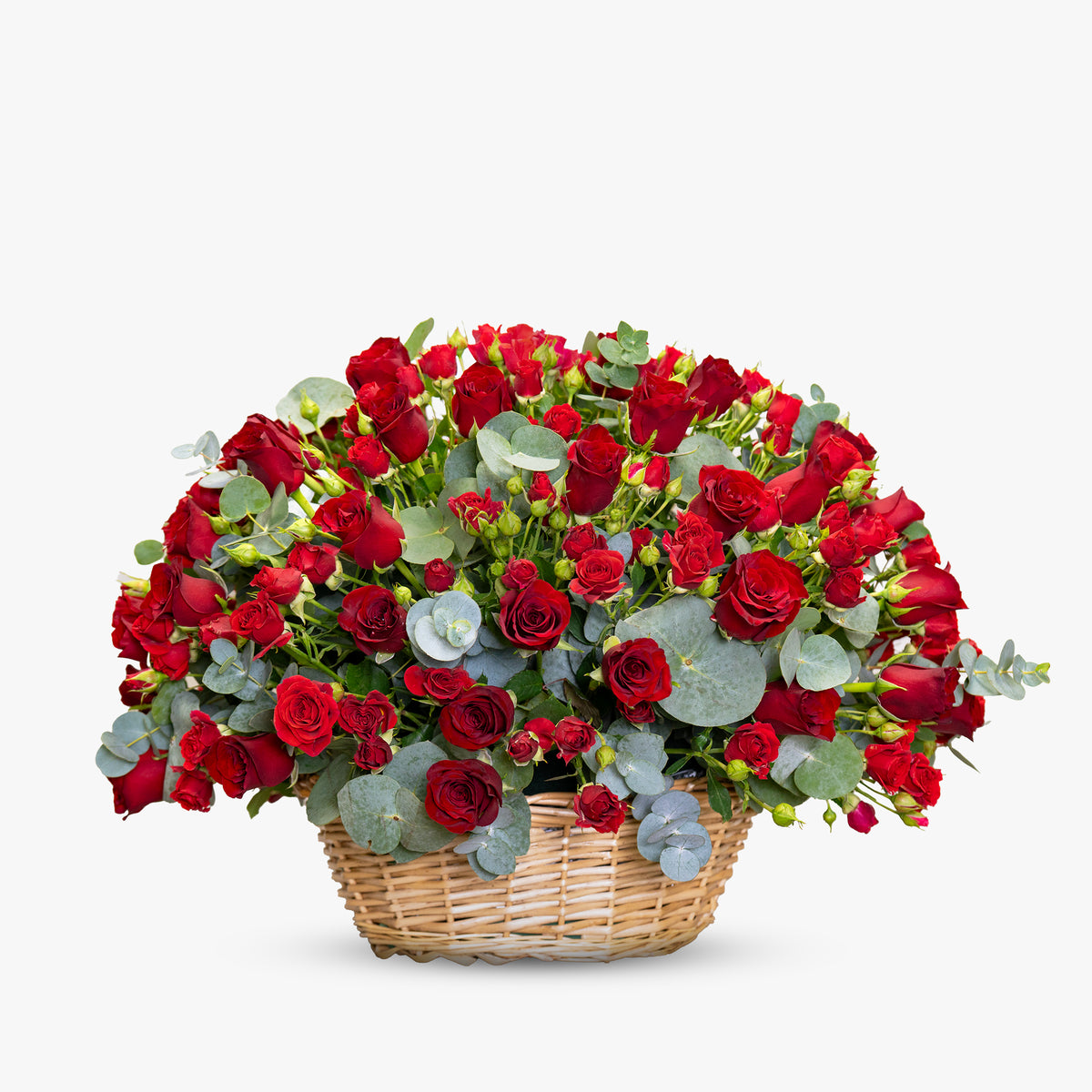Medium woven basket filled with fresh red roses, spray roses, and eucalyptus, arranged for romantic occasions.