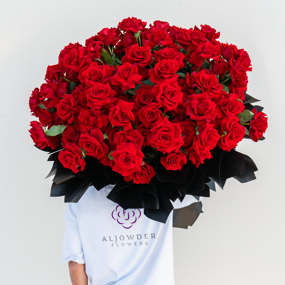Large red roses bouquet for Valentine’s Day wrapped in black luxury paper, romantic flower delivery Dubai