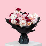 Lovely Kisses bouquet with blush, ivory, and red roses wrapped in black paper, luxury rose bouquet for flower delivery