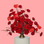 Bouquet of red roses in a vase on a pink background
