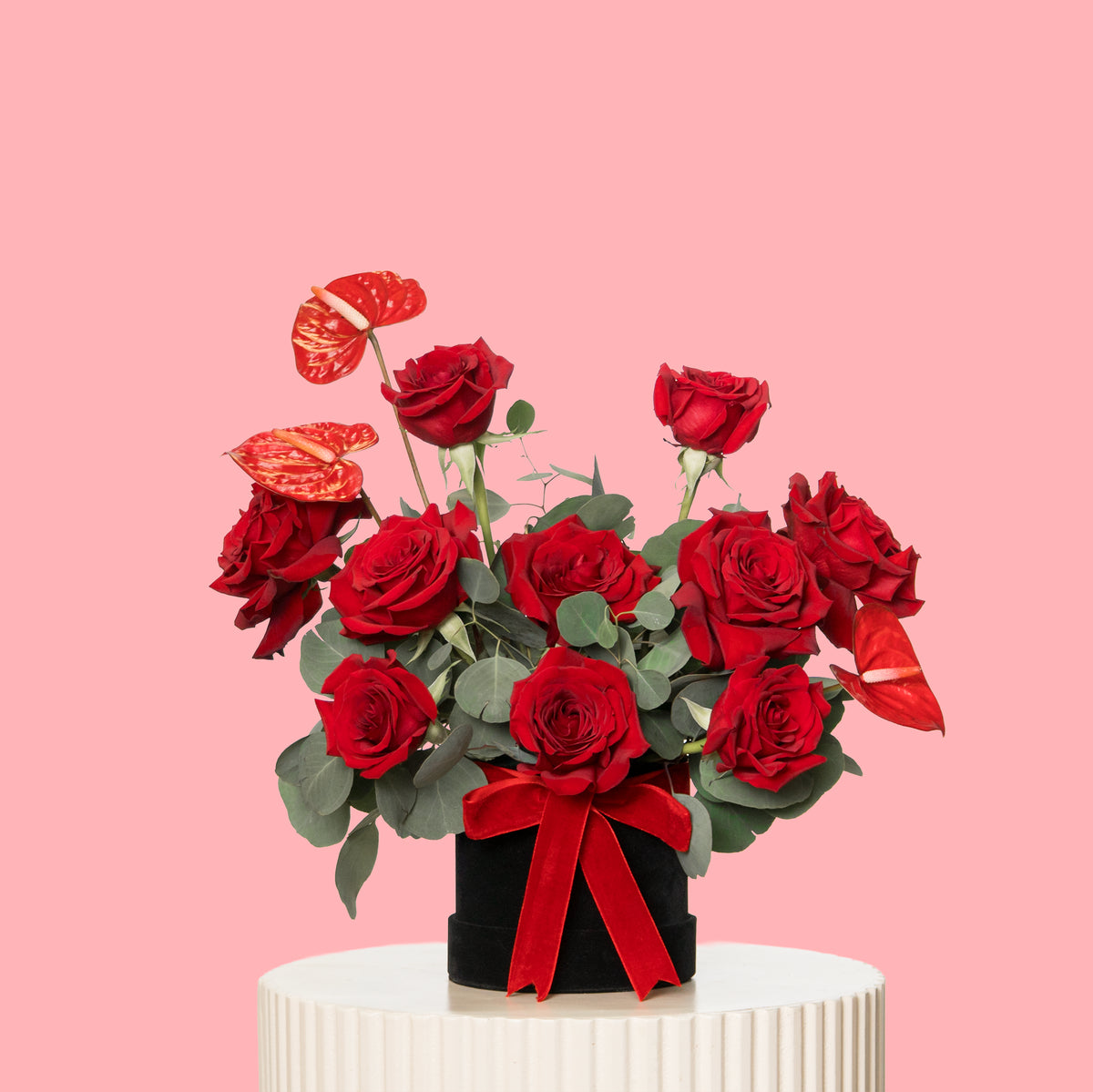 Bouquet of red roses with a red bow on a pink background