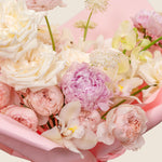 Close-up of a bouquet of pink and white flowers in a pink container.