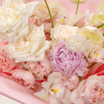 Close-up of a bouquet of pink and white flowers on a pink background