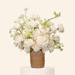 Bouquet of white flowers in a woven basket on a beige background