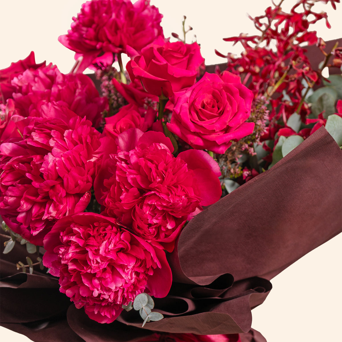 Bouquet of pink flowers wrapped in brown paper on a light background