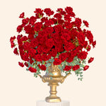 Bouquet of red roses in a gold urn on a white background