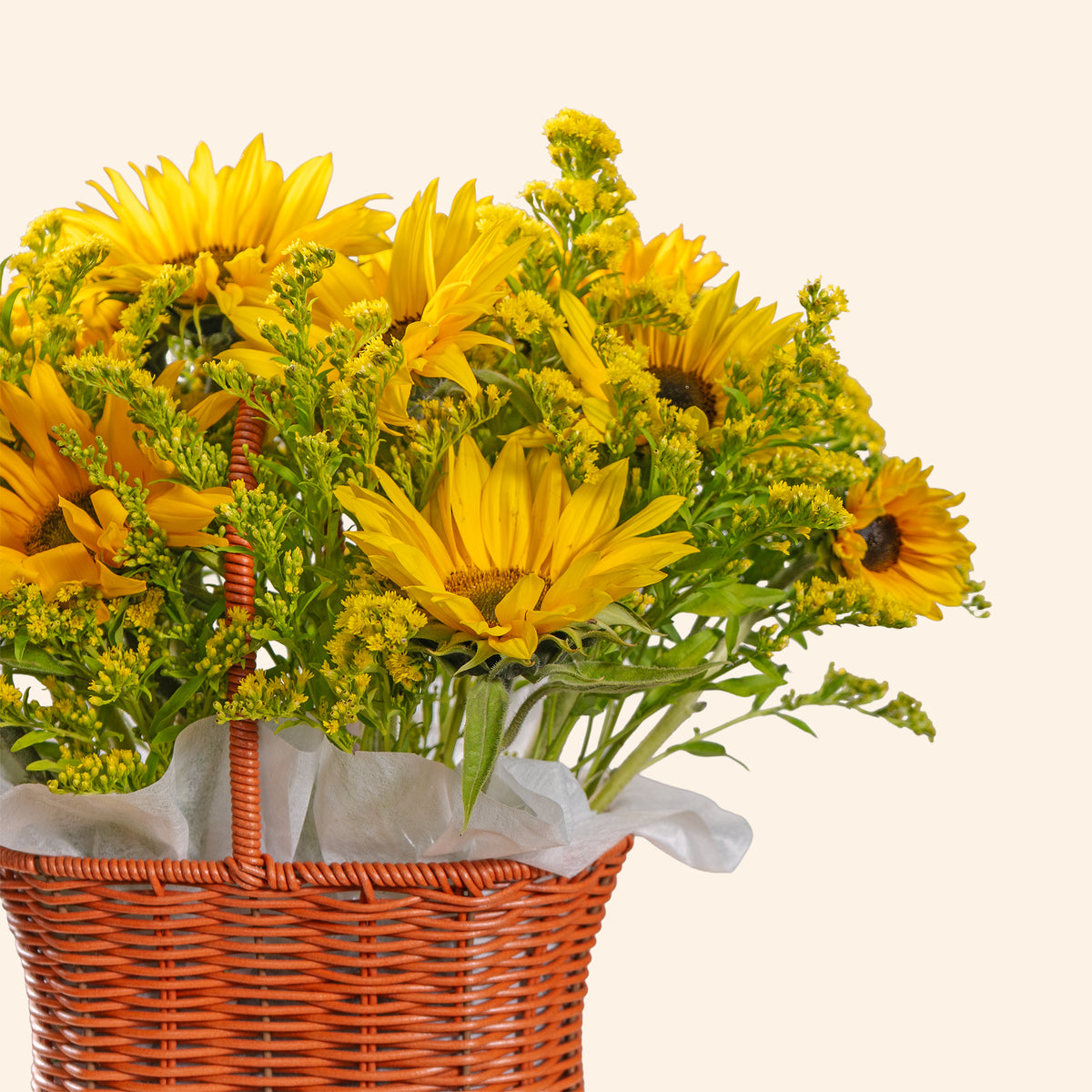 Bouquet of yellow sunflowers in a woven basket on a light beige background