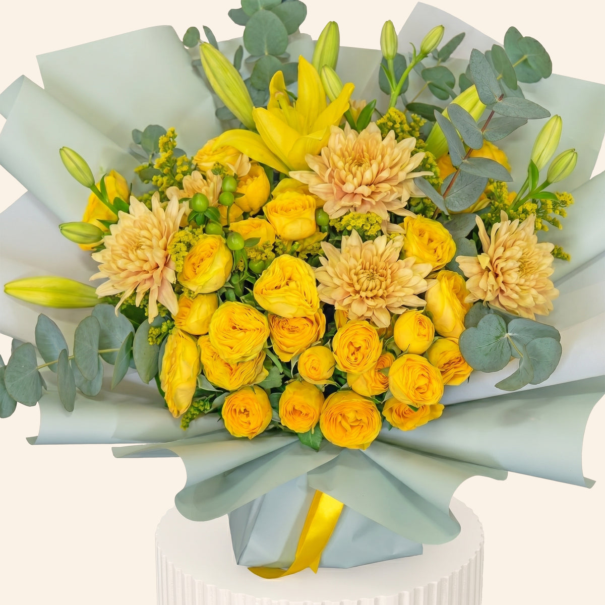 Bouquet of yellow and peach flowers with greenery on a white background