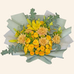 Bouquet of yellow and beige flowers with greenery on a light gray background