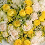 Bouquet of yellow and white roses with greenery