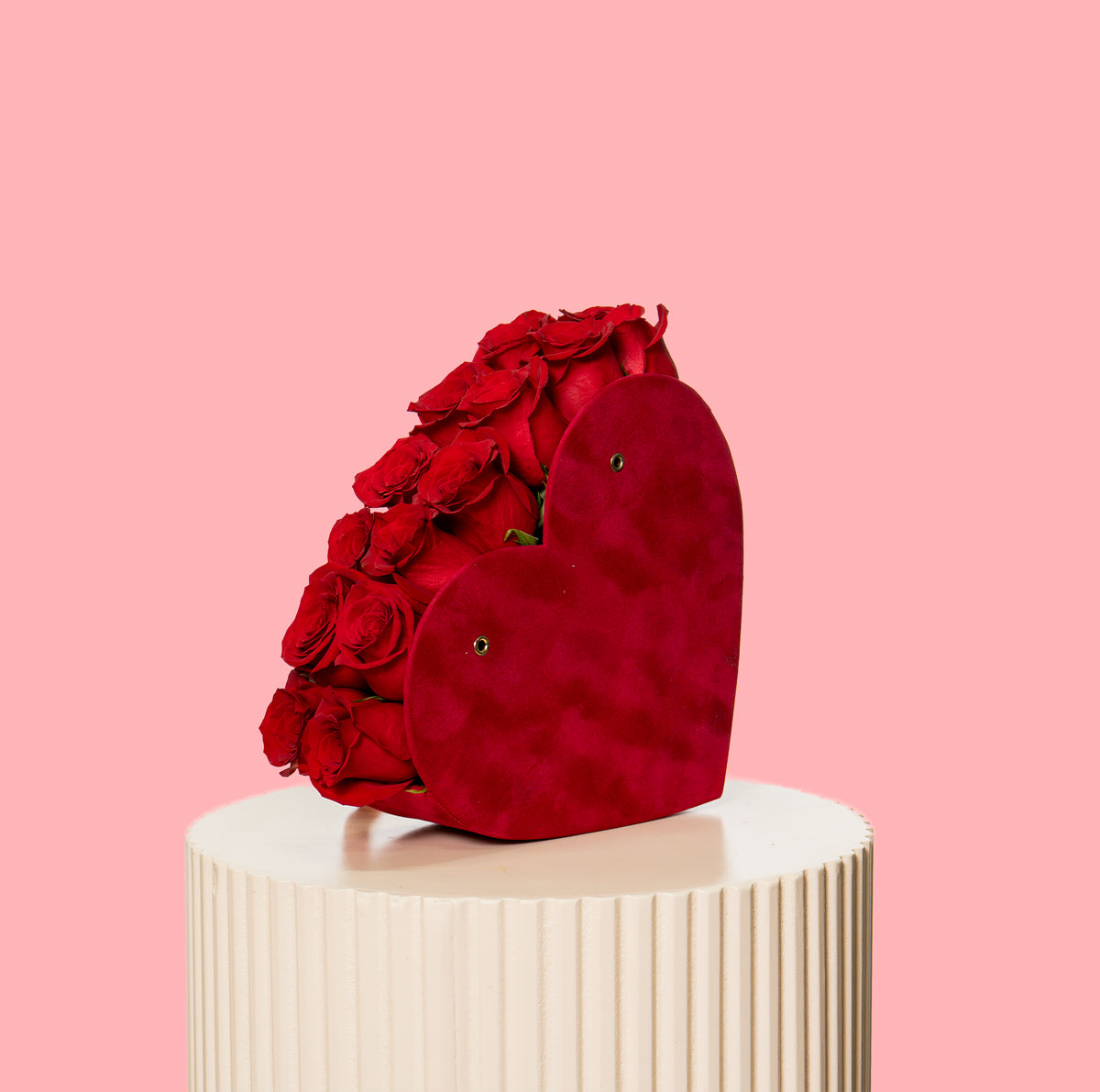 Heart-shaped red bag with roses on a pink background