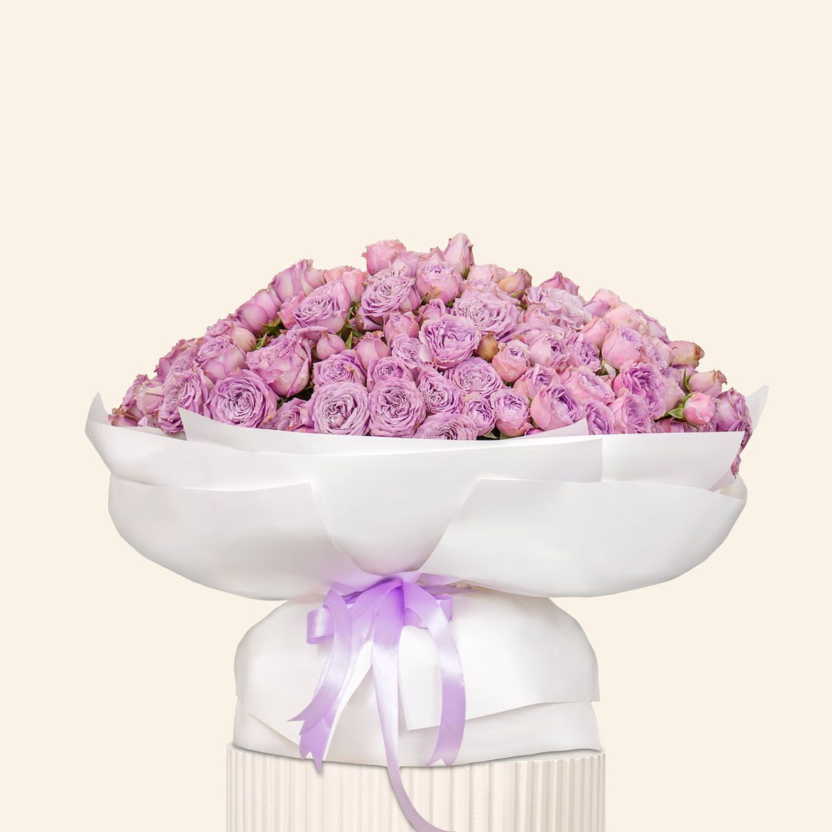 Bouquet of purple flowers in a white container with a purple ribbon on a light beige background