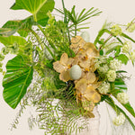Bouquet of gold orchids and greenery on a white background