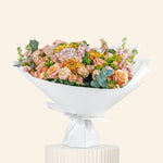 Floral arrangement in a white decorative bowl on a light beige background