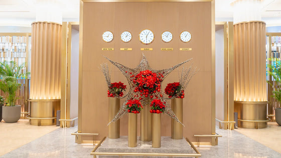 Festive star-shaped floral installation set beneath global time zone clocks in a First Class Lounge