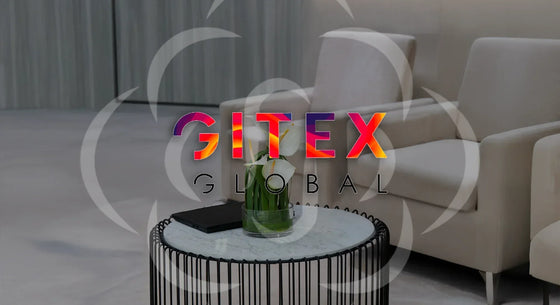 Small modern table with a glass vase of white calla lilies placed in a sleek lounge setting at GITEX Global exhibition in Dubai.