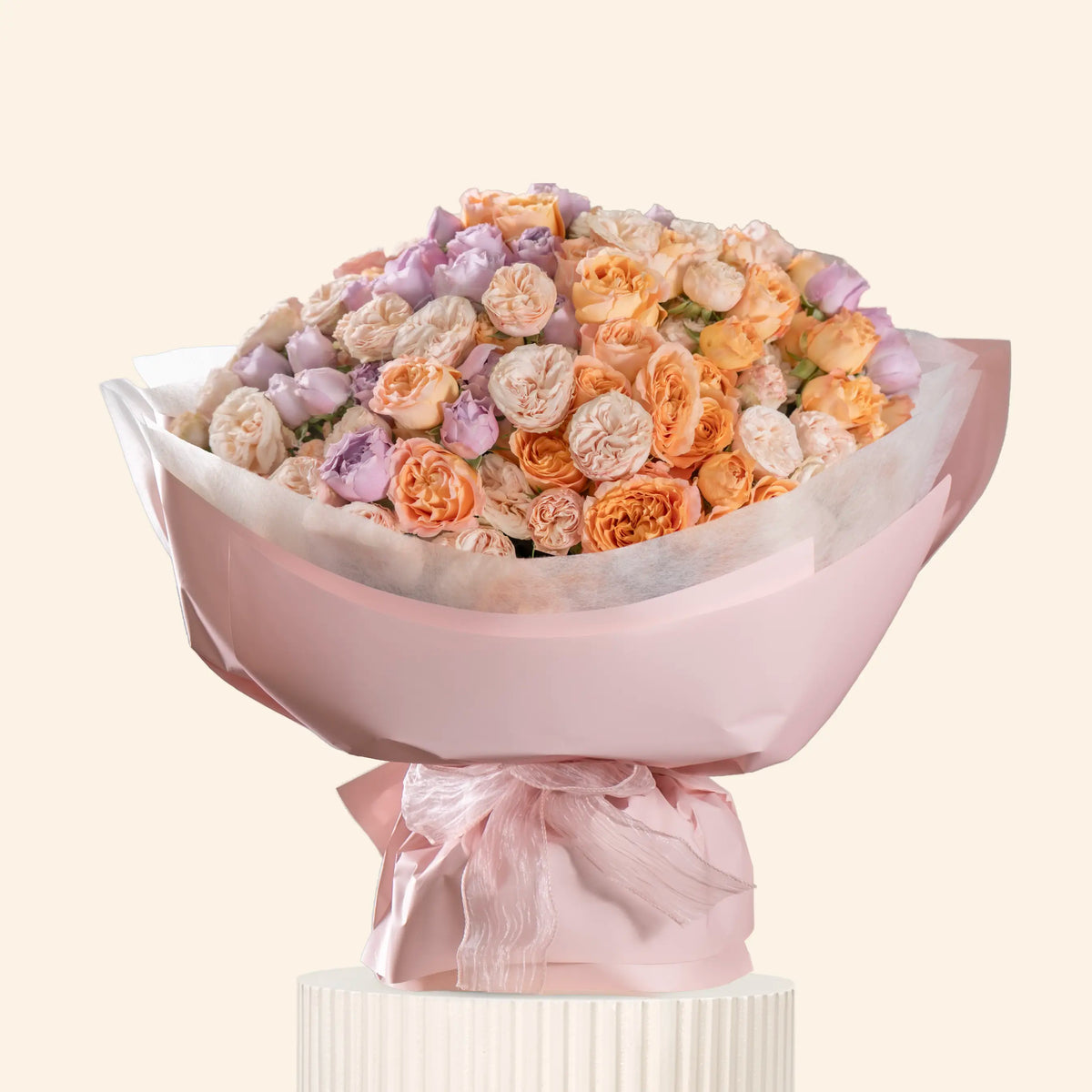Bouquet of flowers wrapped in pink paper on a white background