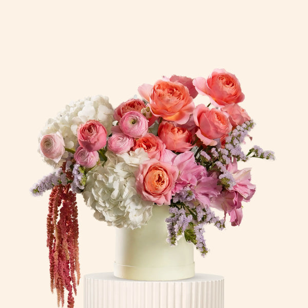 Floral arrangement with pink and white flowers in a vase on a light background