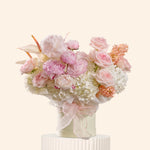 Floral arrangement with pink and white flowers in a vase on a light background