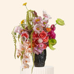 Bouquet of flowers in a black vase on a white background