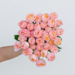 Bouquet of pink roses held by a person on a light background