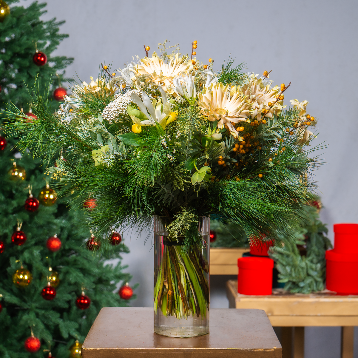 Bouquet of flowers in a vase with a Christmas tree in the background