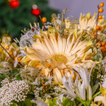 Close-up of a bouquet with yellow flowers and berries against a blurred background