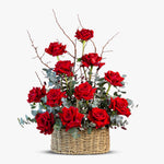 Basket of red roses with eucalyptus on a white background