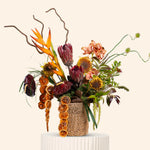 Decorative floral arrangement with dried elements on a beige background