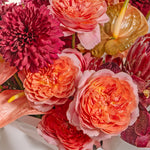 Close-up of a bouquet of pink, red, and orange flowers with anthuriums.