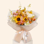 Bouquet of flowers with sunflowers and other varieties wrapped in white paper and ribbon on a white background