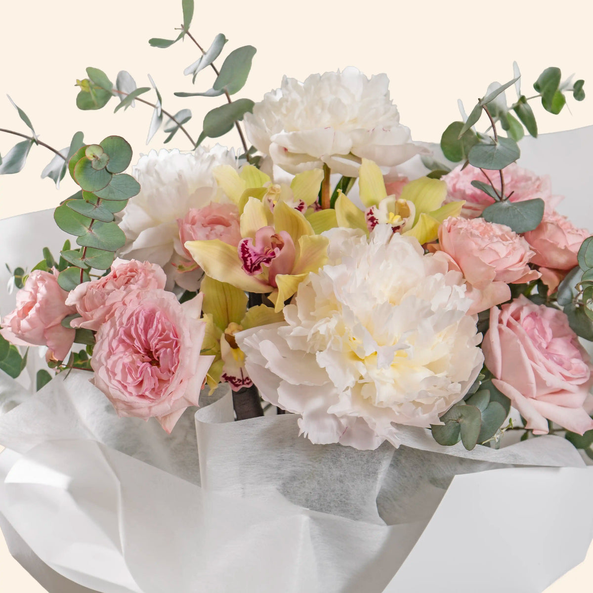 Bouquet of flowers with pink roses, white peonies, and greenery on a light background
