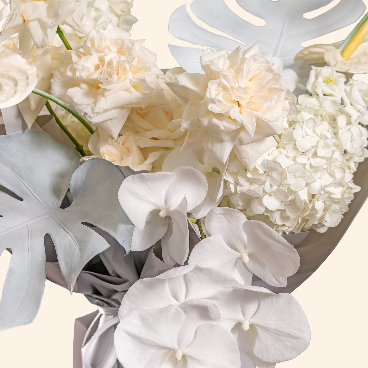 Bouquet of white flowers with gray leaves on a light background