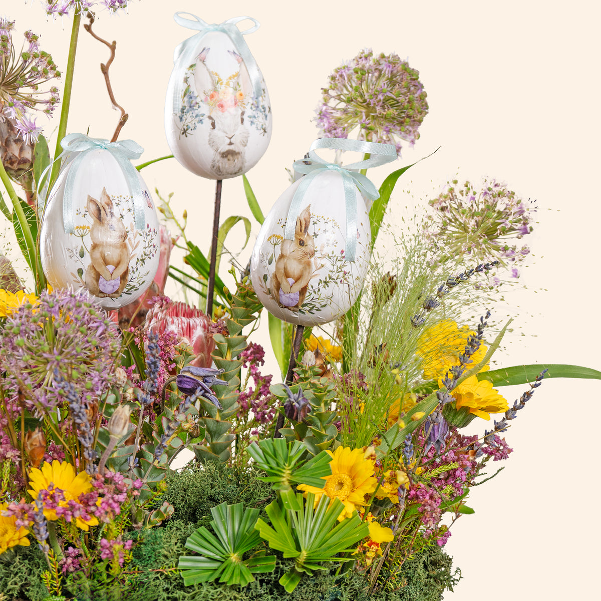 Decorative Easter eggs with rabbit designs on a floral arrangement.