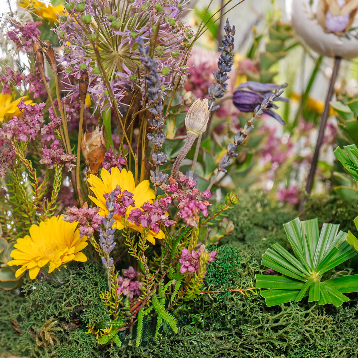 Close-up of a bouquet with yellow and purple flowers on a green background